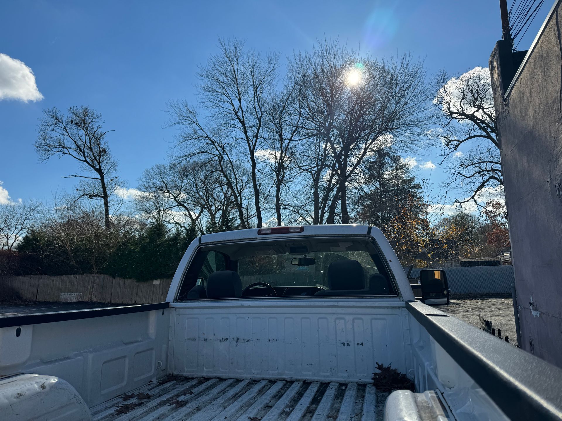 a white truck is parked in a parking lot with trees in the background