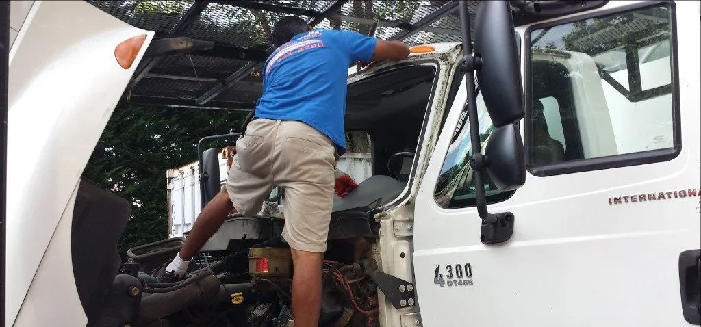 A man is working on the engine of a truck