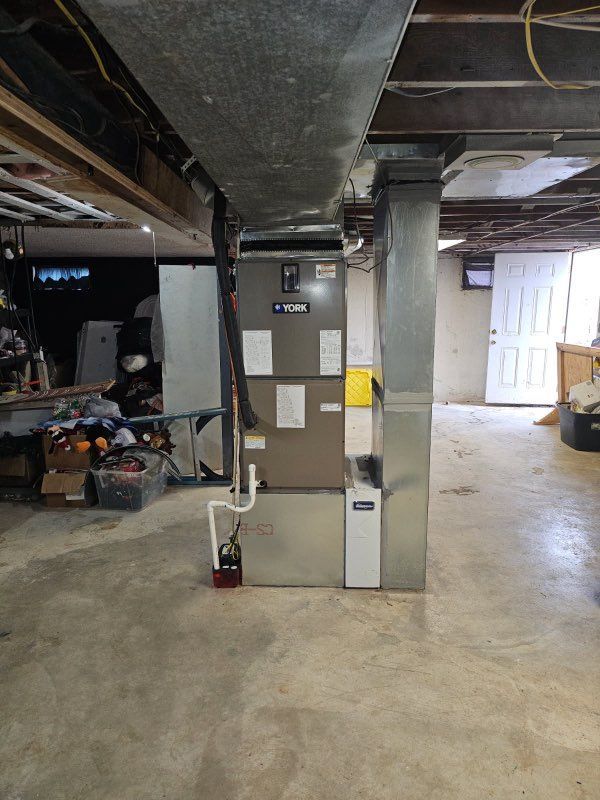 Basement utility area with HVAC equipment, exposed ductwork, and concrete floors.