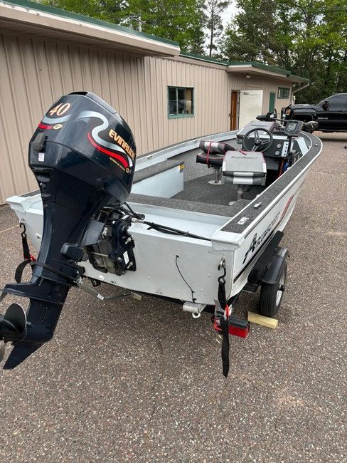A boat is parked on a trailer in front of a building.