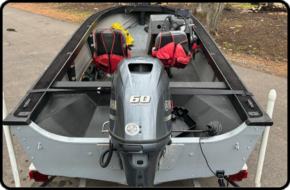 A fishing boat with a 60 hp engine is parked on the side of the road