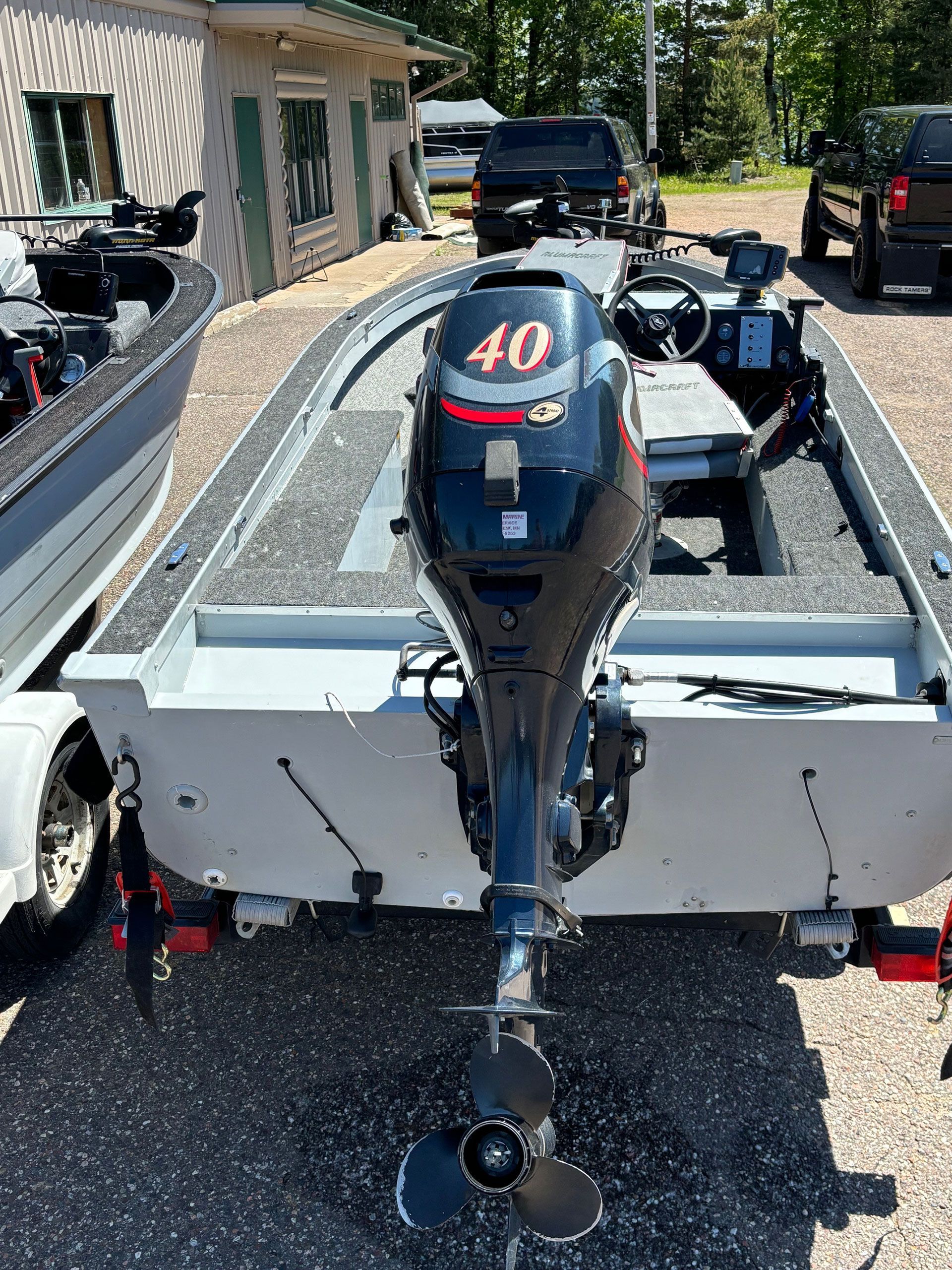 A boat with a 40 hp outboard motor is parked in a parking lot