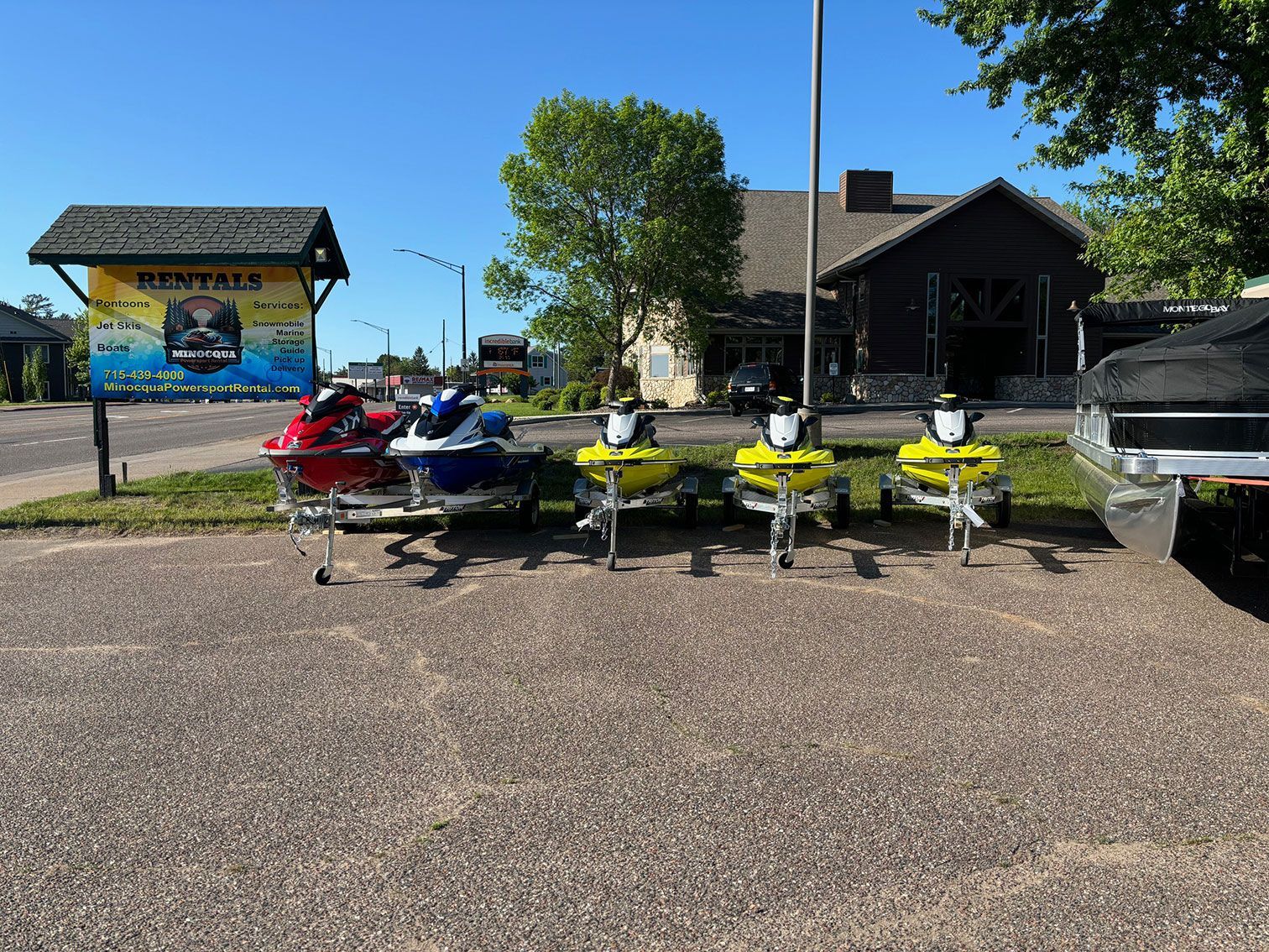 A row of jet skis are parked in a parking lot