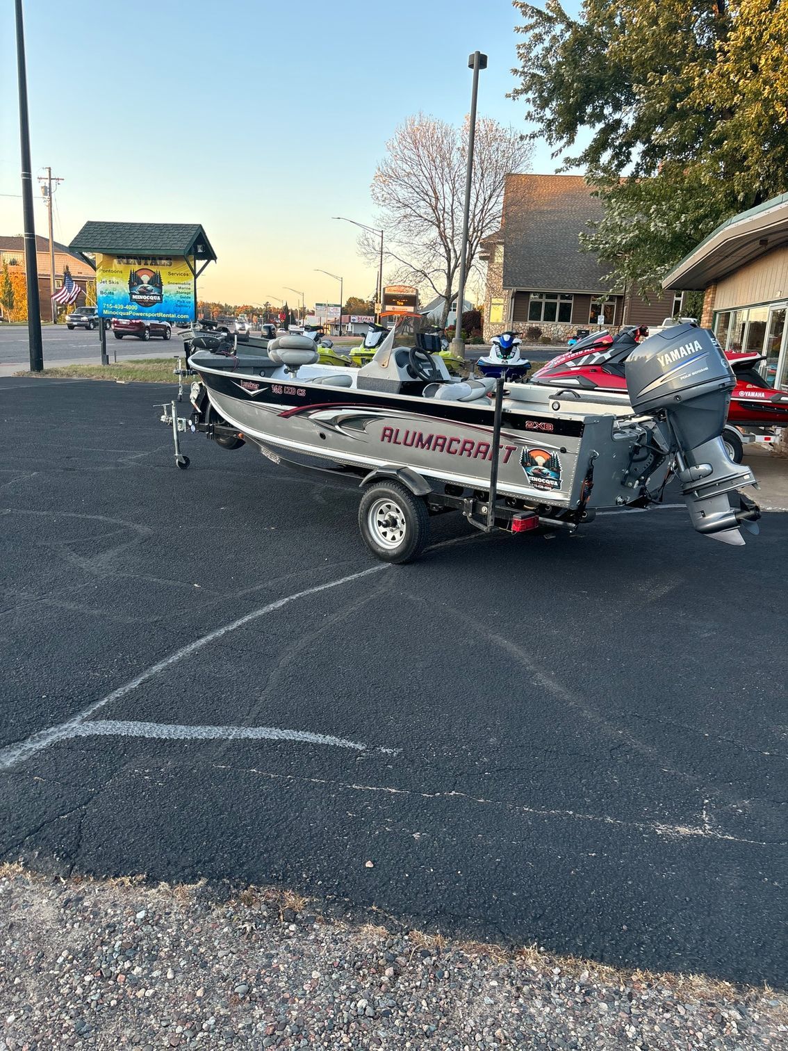 A boat is parked on a trailer in a parking lot.