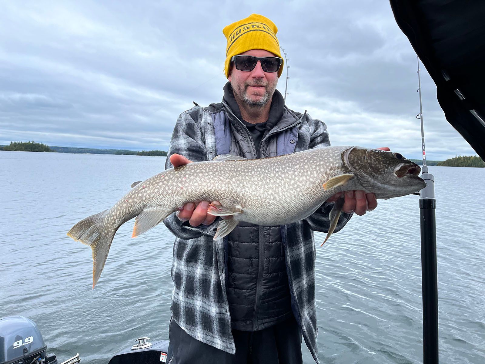 A man is holding a large trout