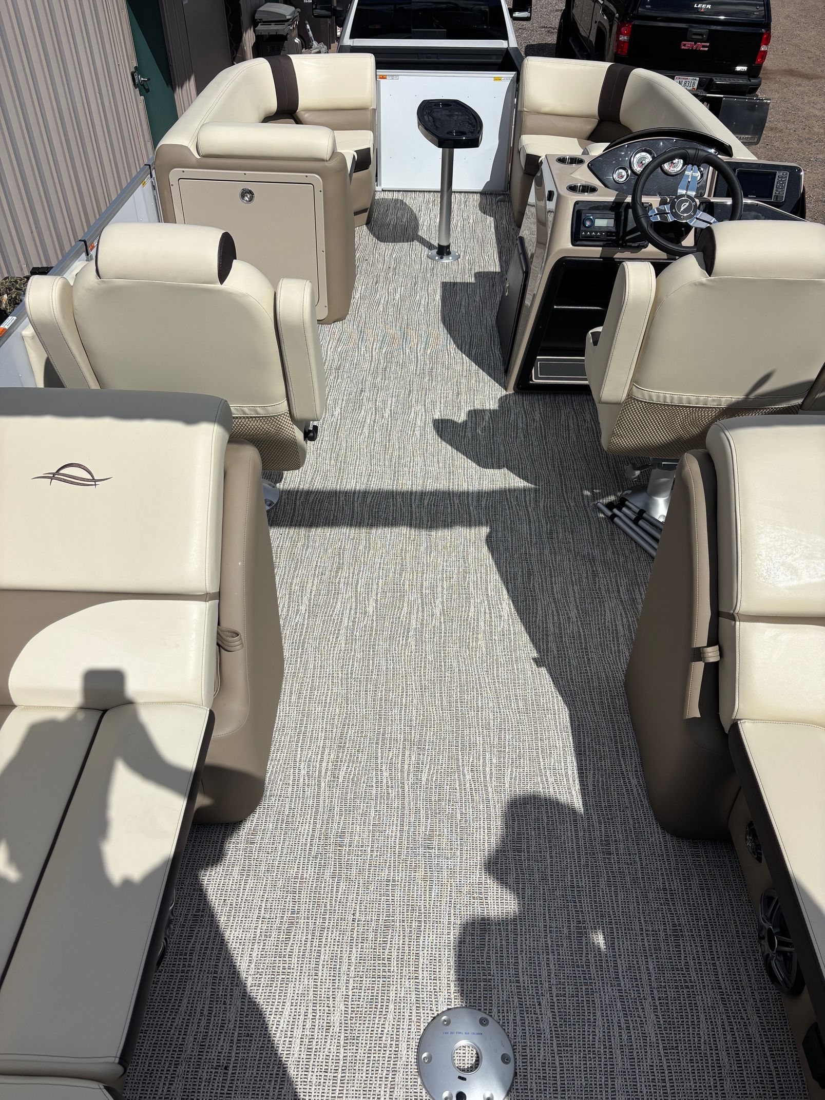 View from a boat deck with beige seats and a central walkway leading to the stern.