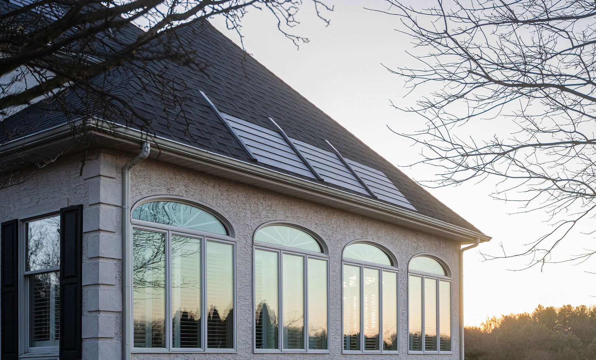 A house with arched windows and solar panels on the roof
