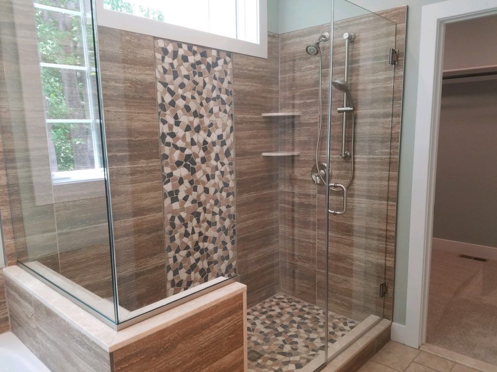 a bathroom with a walk in shower and a window
