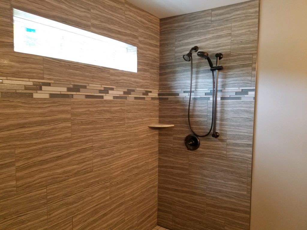 a walk in shower with a window and a shower head