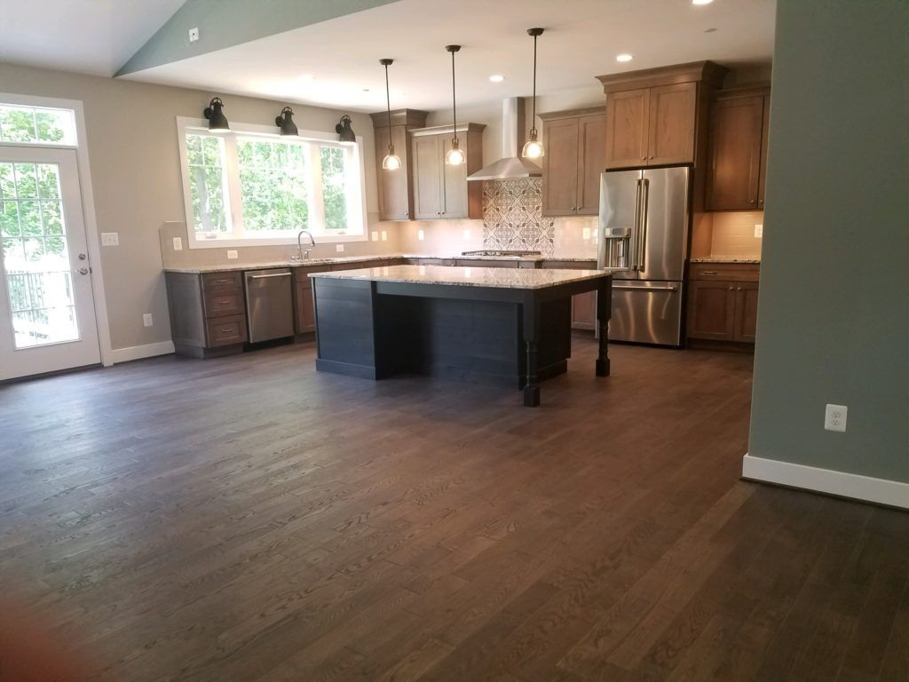 a kitchen with a large island and stainless steel appliances .