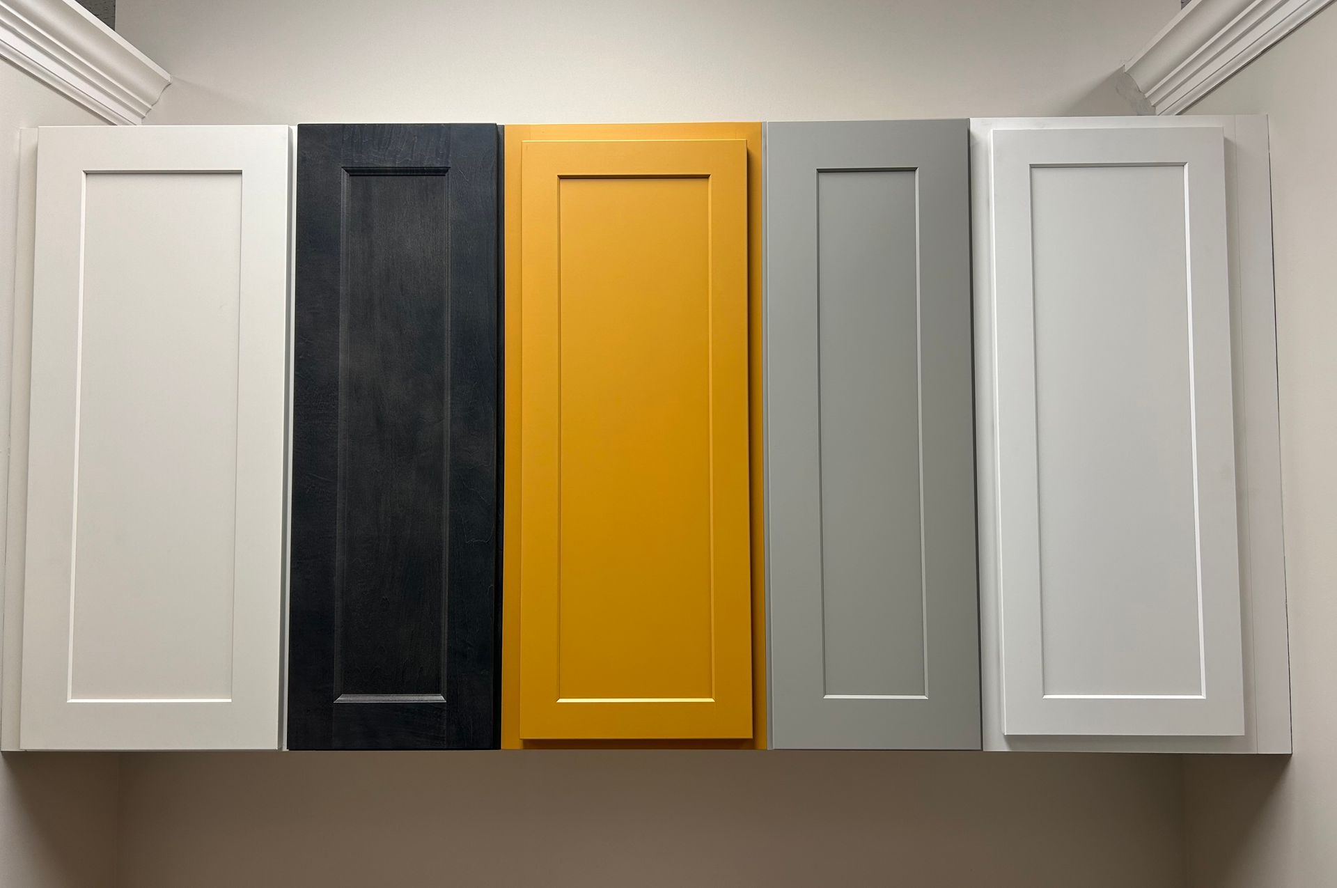 four different colored cabinet doors are lined up on a wall