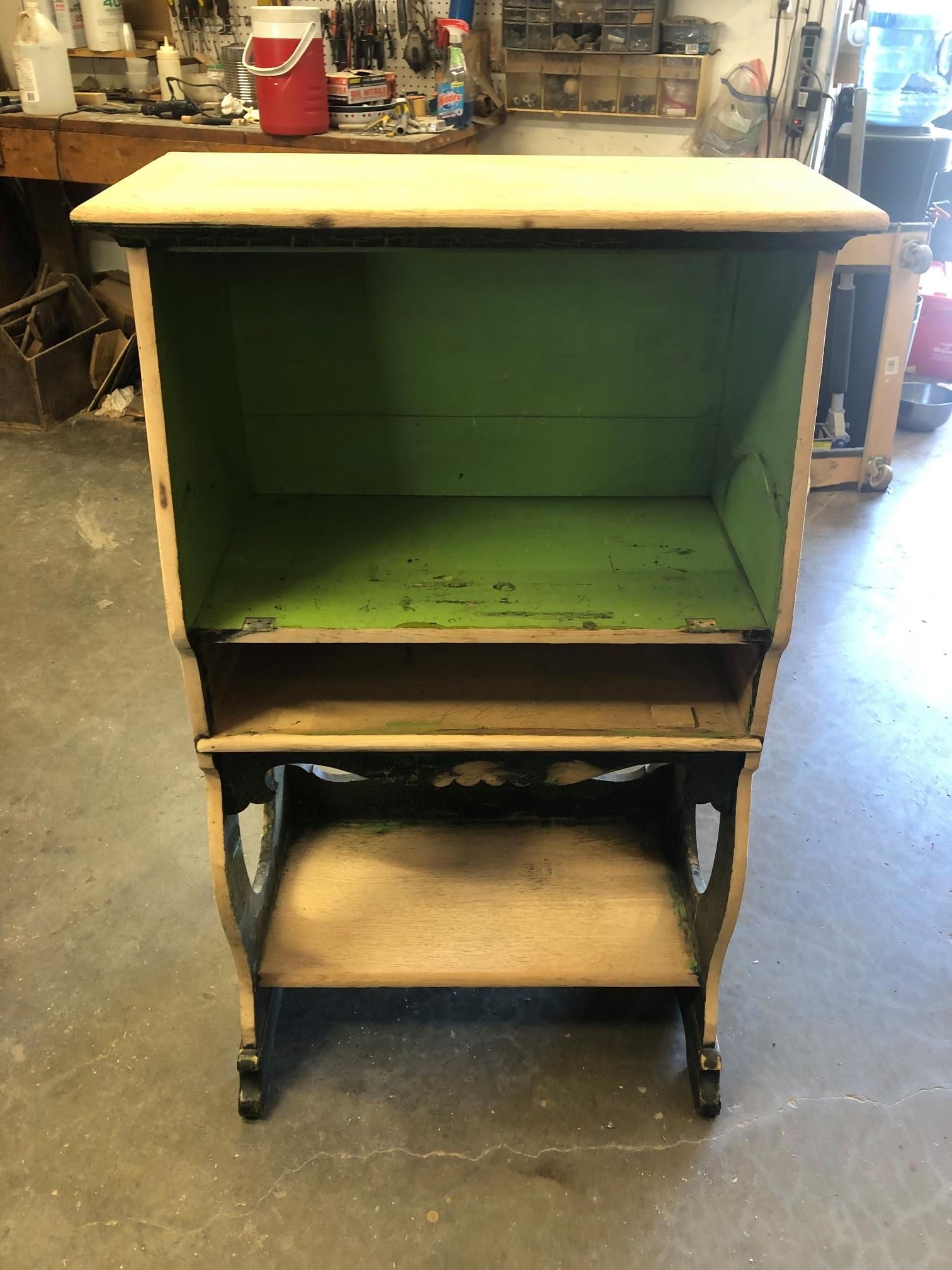 a wooden shelf with a green top is sitting on a concrete floor