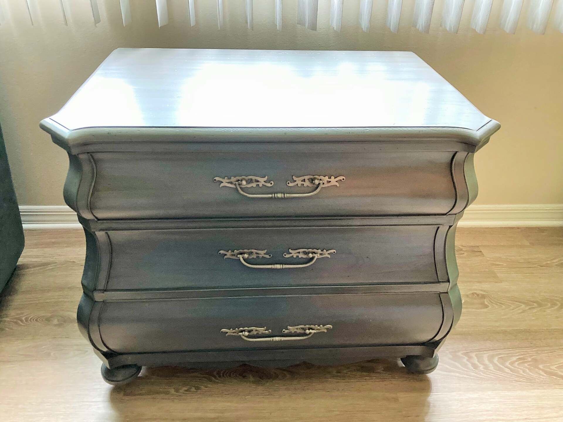 a small dresser with three drawers is sitting on a wooden floor