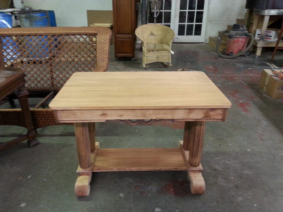 a small wooden table in a room with wicker furniture