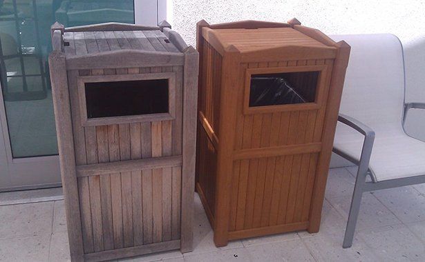 two wooden trash cans are sitting next to each other