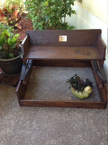 a wooden bench with a potted plant on top of it