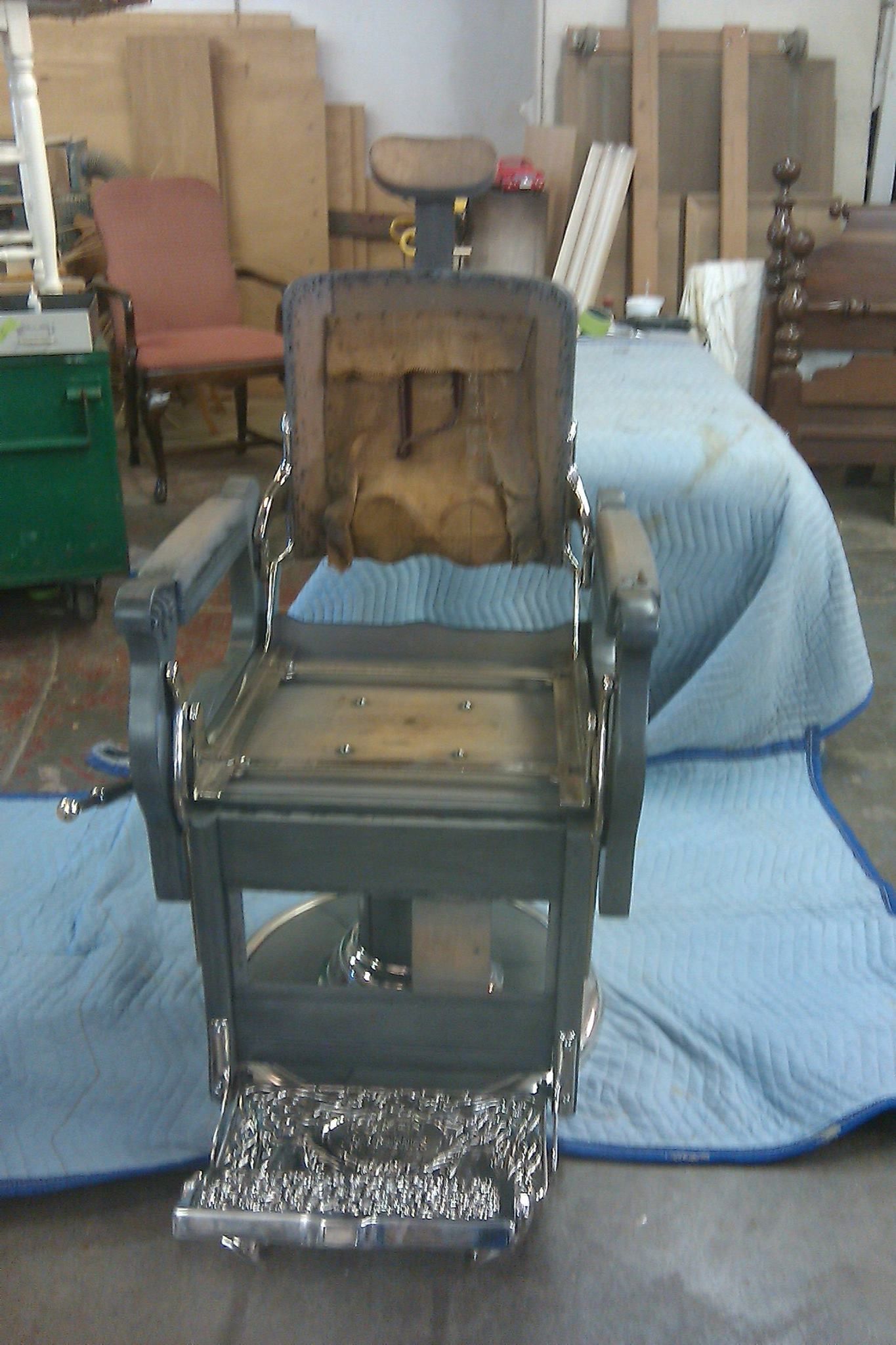 an old barber chair is sitting on a blue blanket