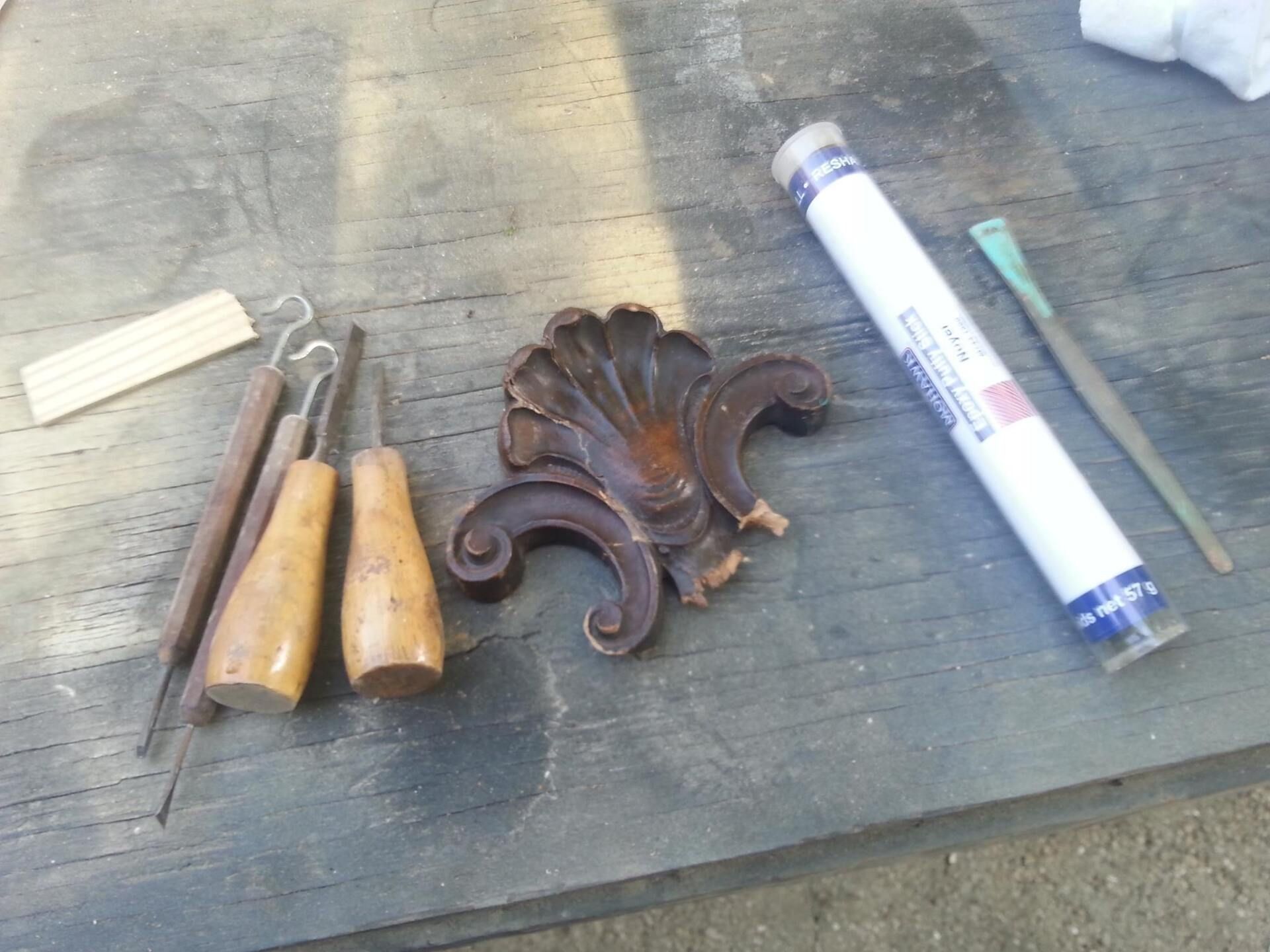 a wooden table with tools and a tube of glue