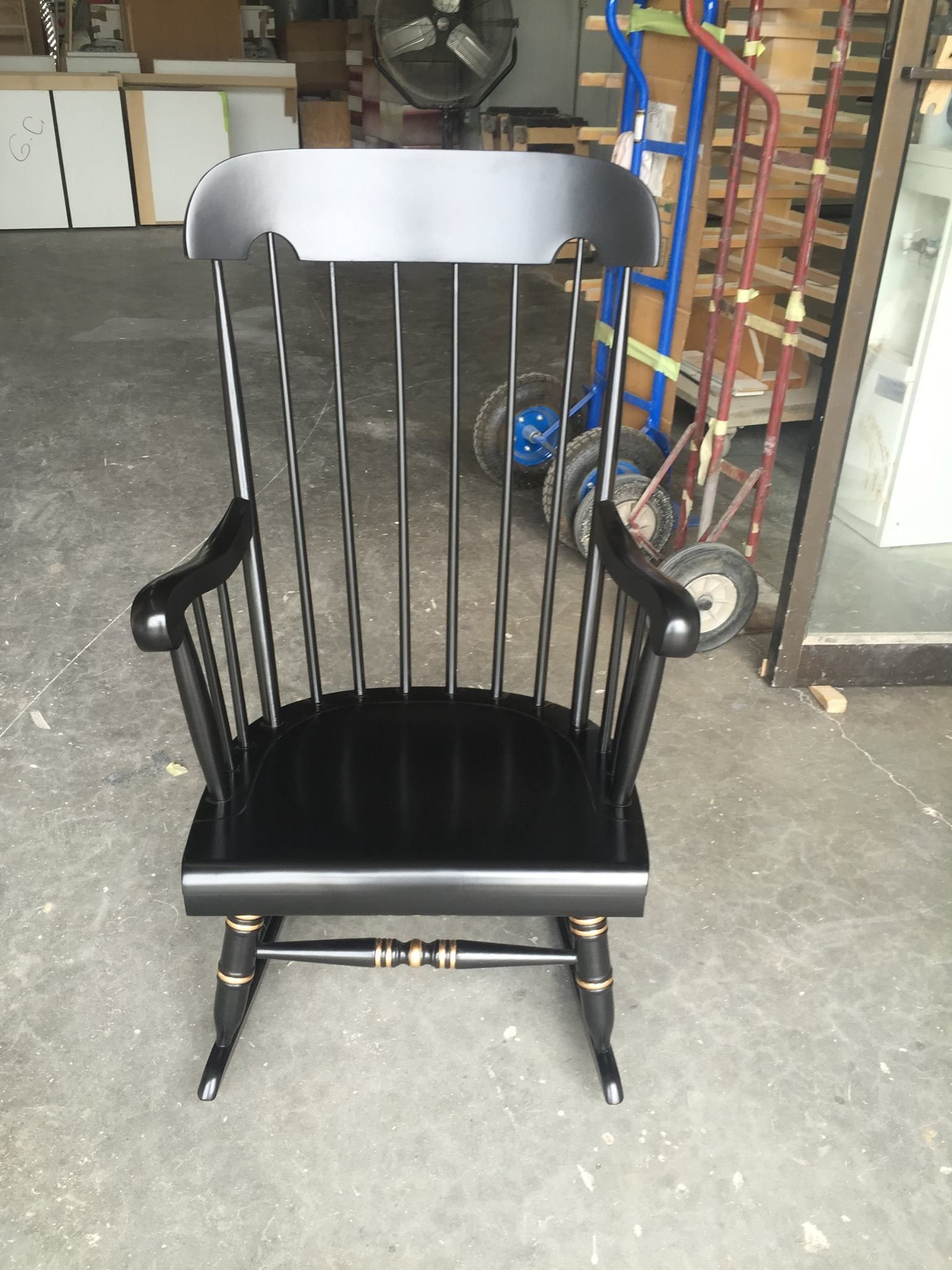 a black wooden rocking chair is sitting in a garage
