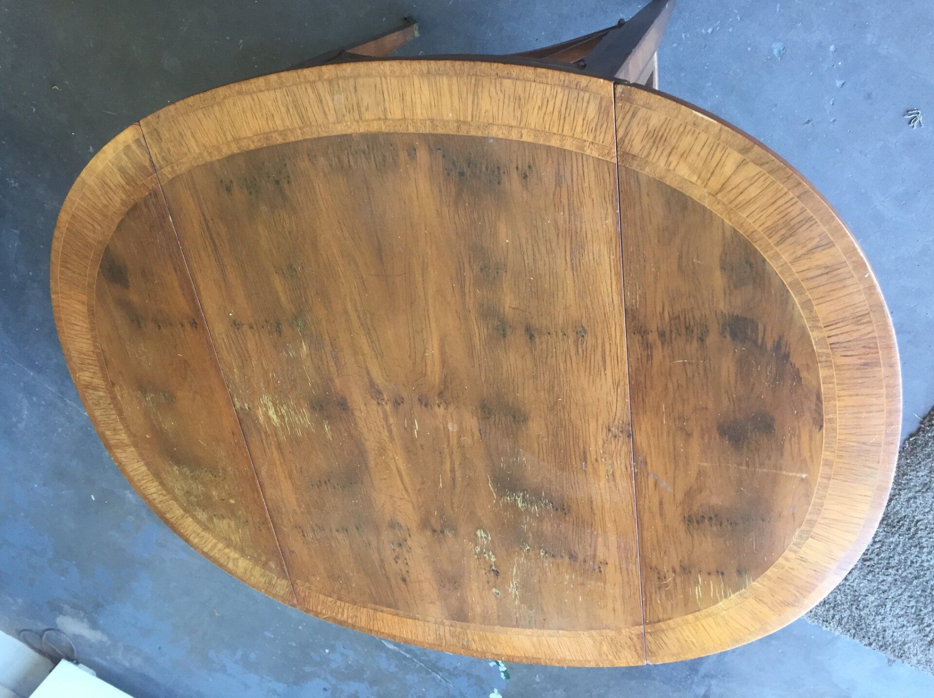 an oval wooden table is sitting on a concrete floor