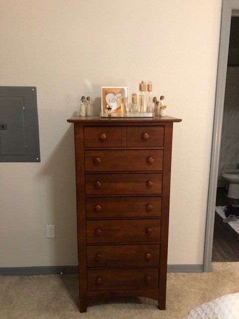 a chest of drawers is sitting in a bedroom next to a wall
