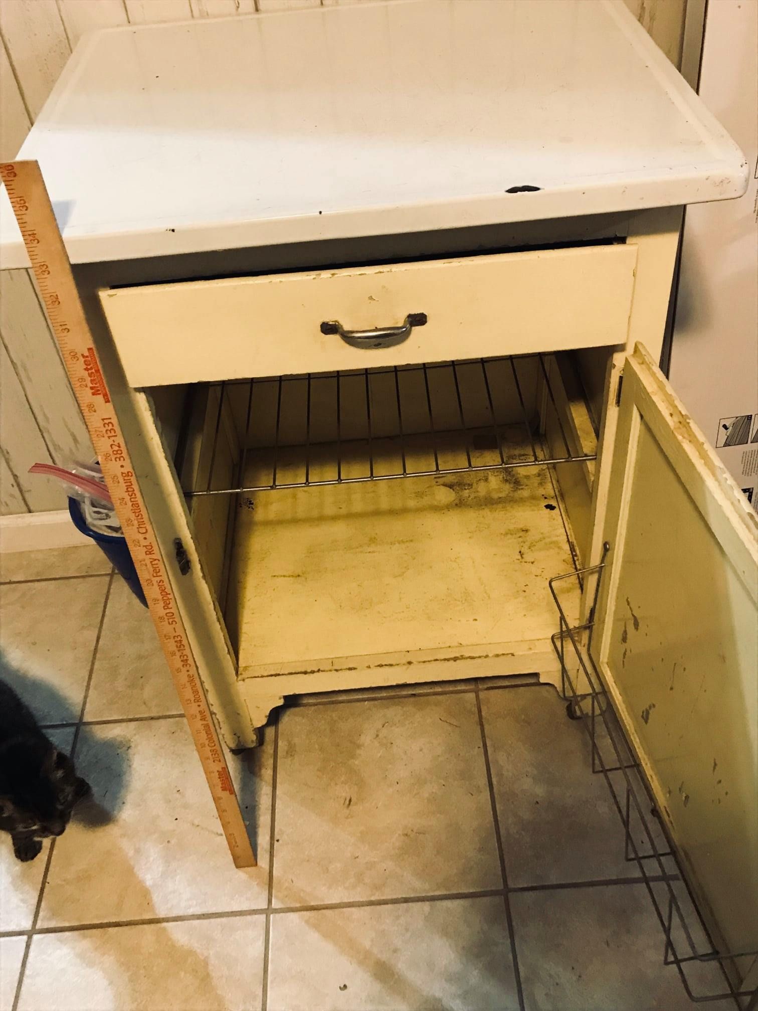 an empty cabinet with a drawer and a ruler on the side