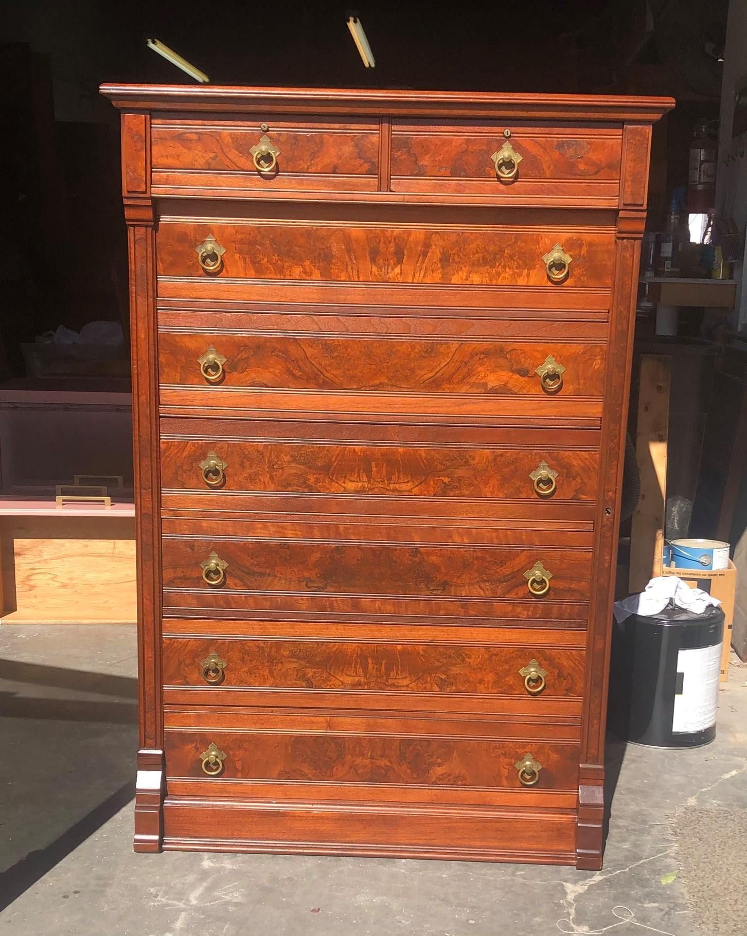 a tall wooden chest of drawers with gold handles