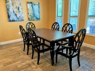 a dining room with a table and chairs and paintings on the wall