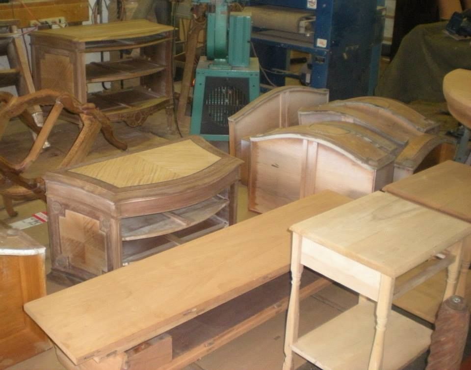 a bunch of wooden tables and chairs in a workshop