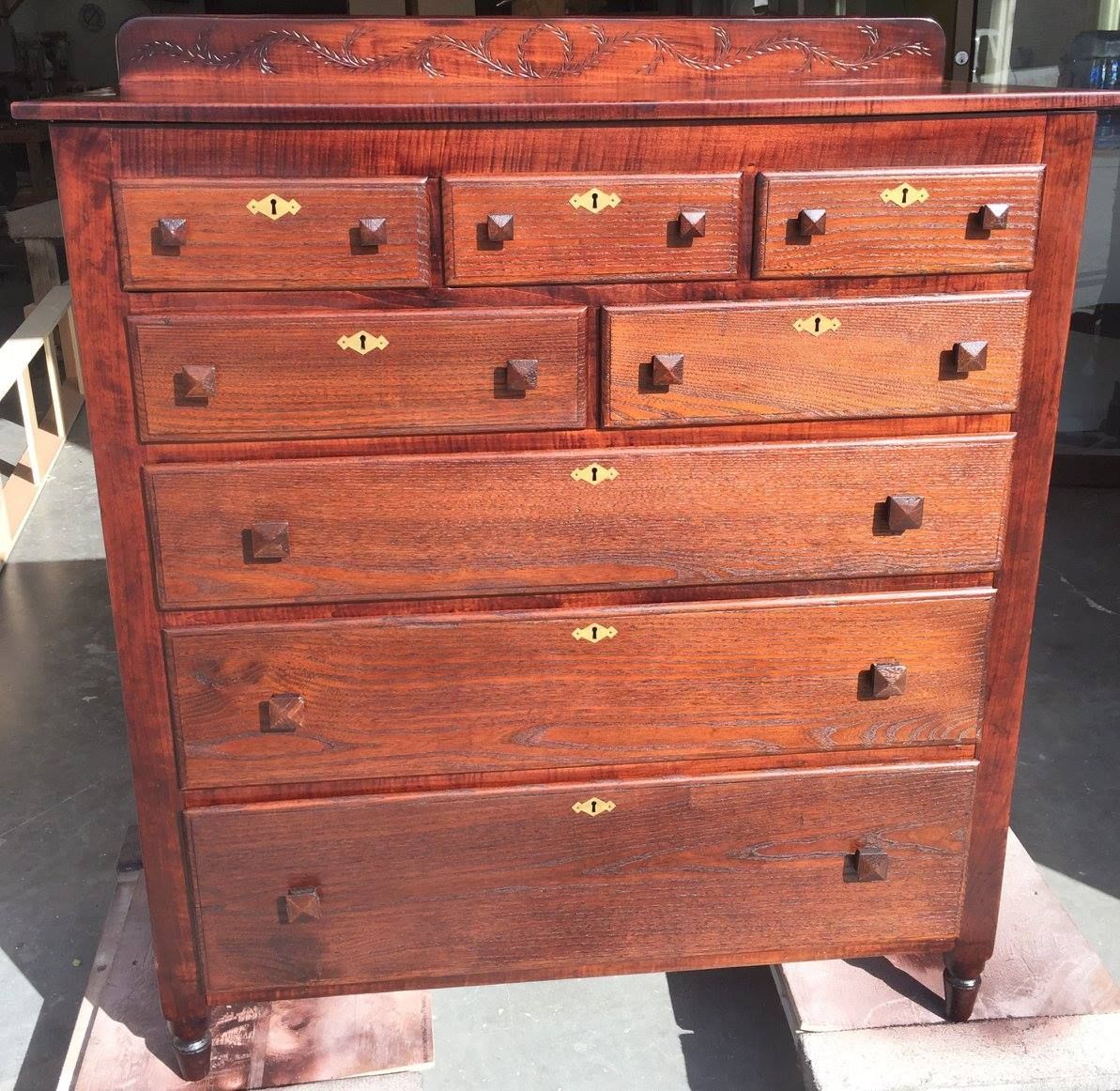 a large wooden chest of drawers with brass handles