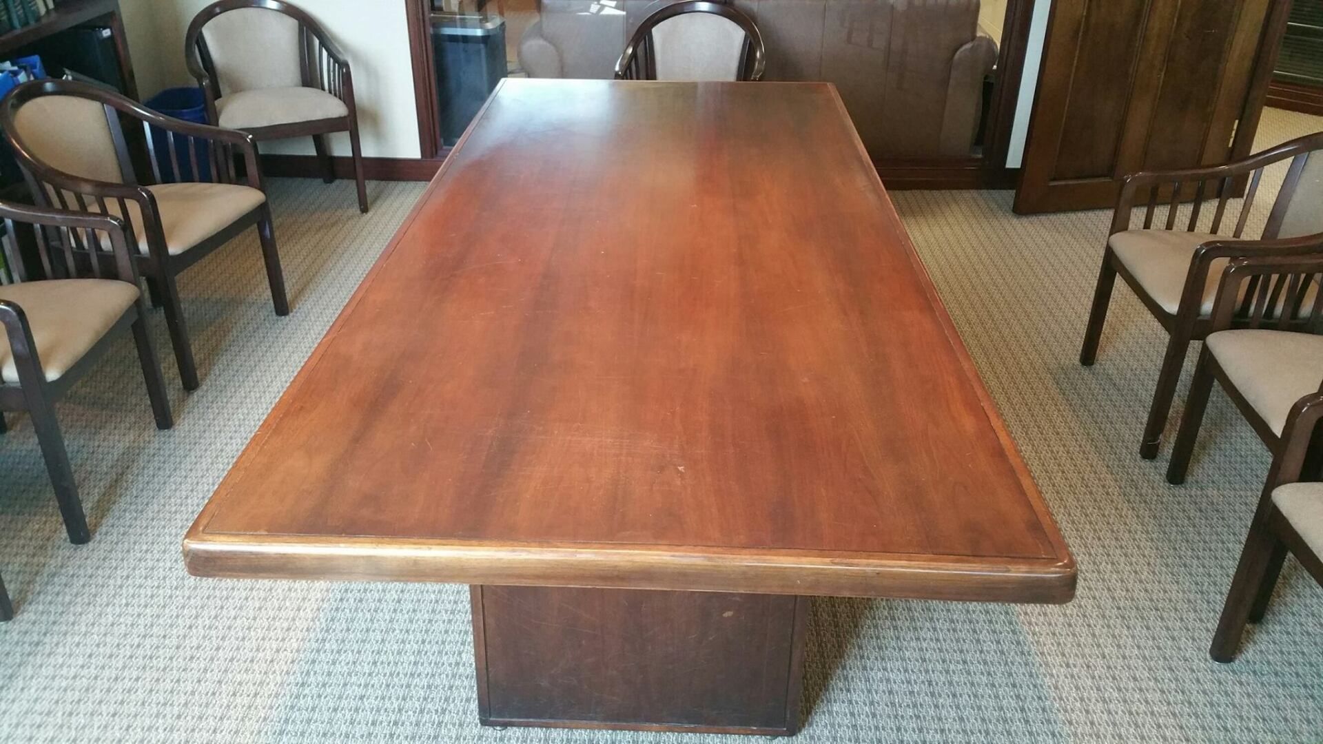 a long wooden table with chairs around it in a room