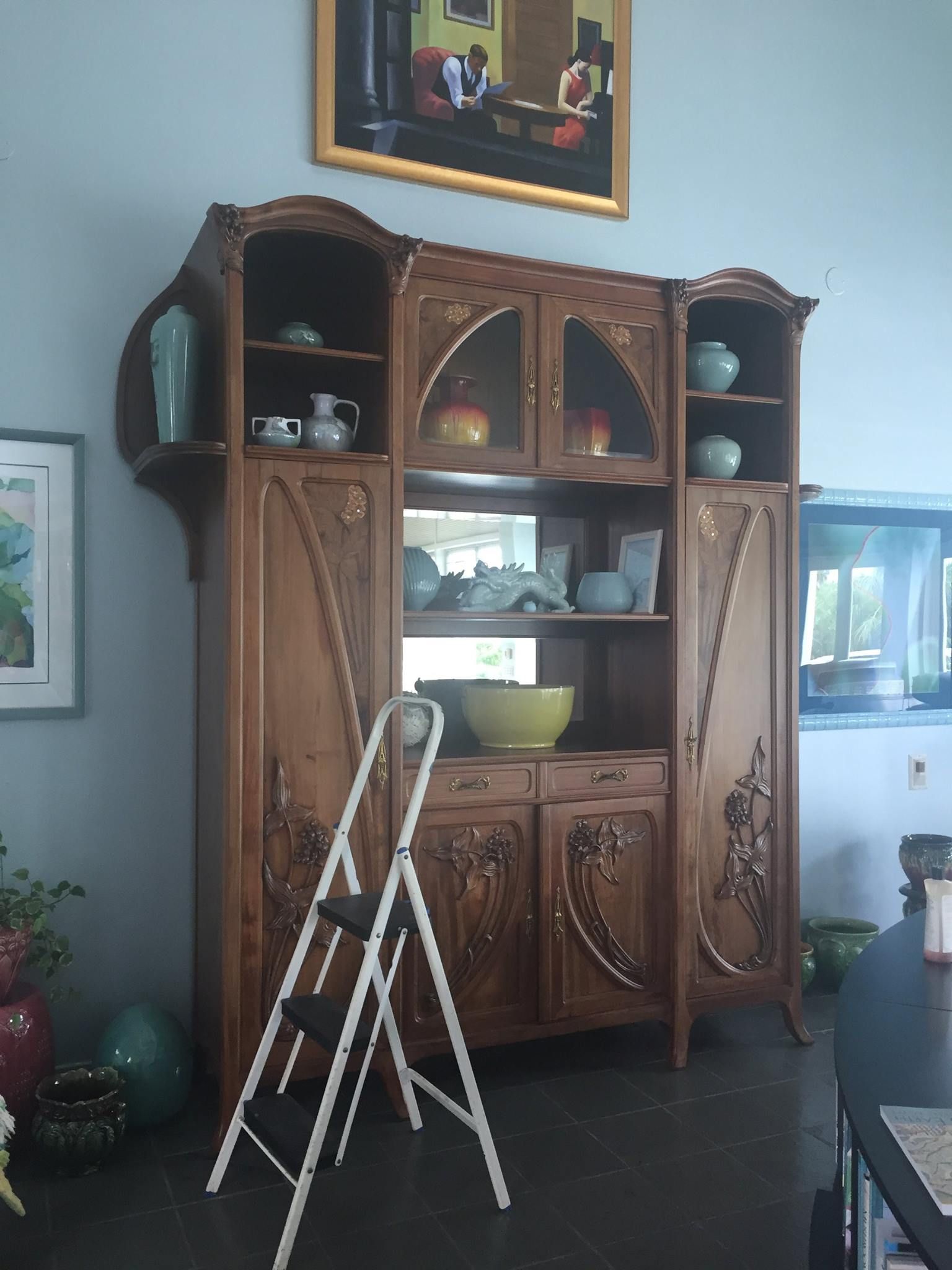 a wooden cabinet with a ladder in front of it
