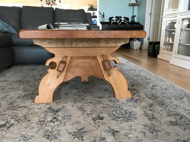 a wooden coffee table is sitting on a rug in a living room