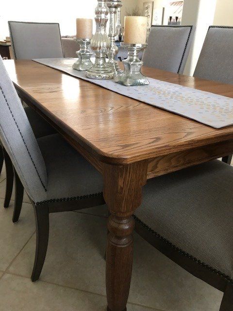 a dining room table with a runner and candles on it