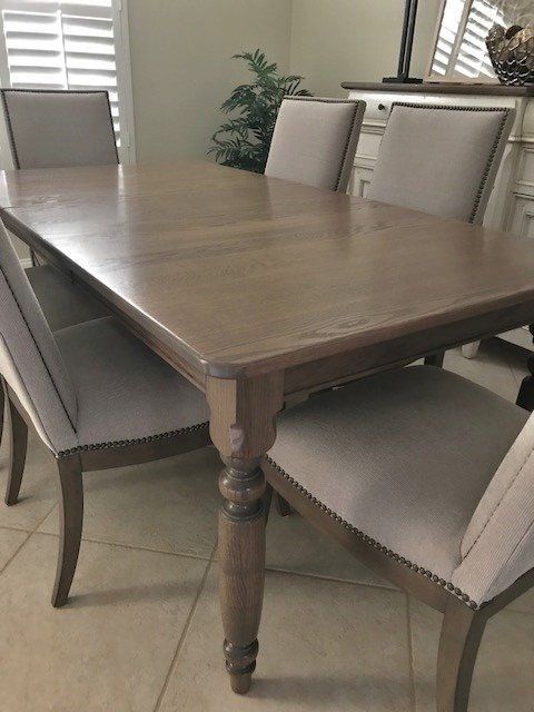 a wooden dining table with chairs and a bench in a dining room