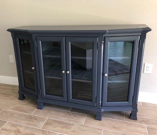 a blue cabinet with glass doors is sitting on a tiled floor in a living room
