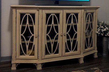 a tv is sitting on top of a wooden entertainment center in a living room