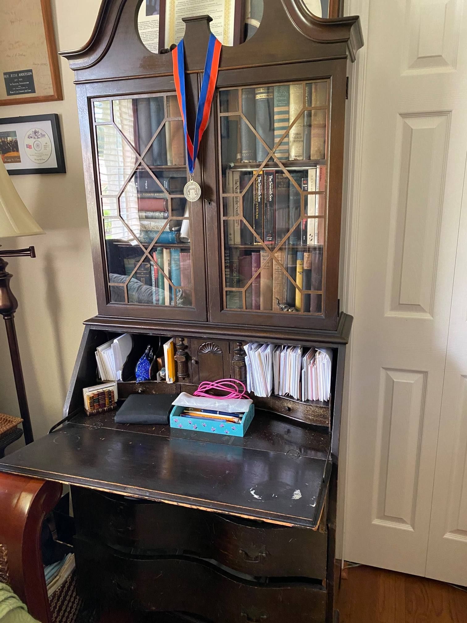 a wooden desk with a medal on top of it in a living room