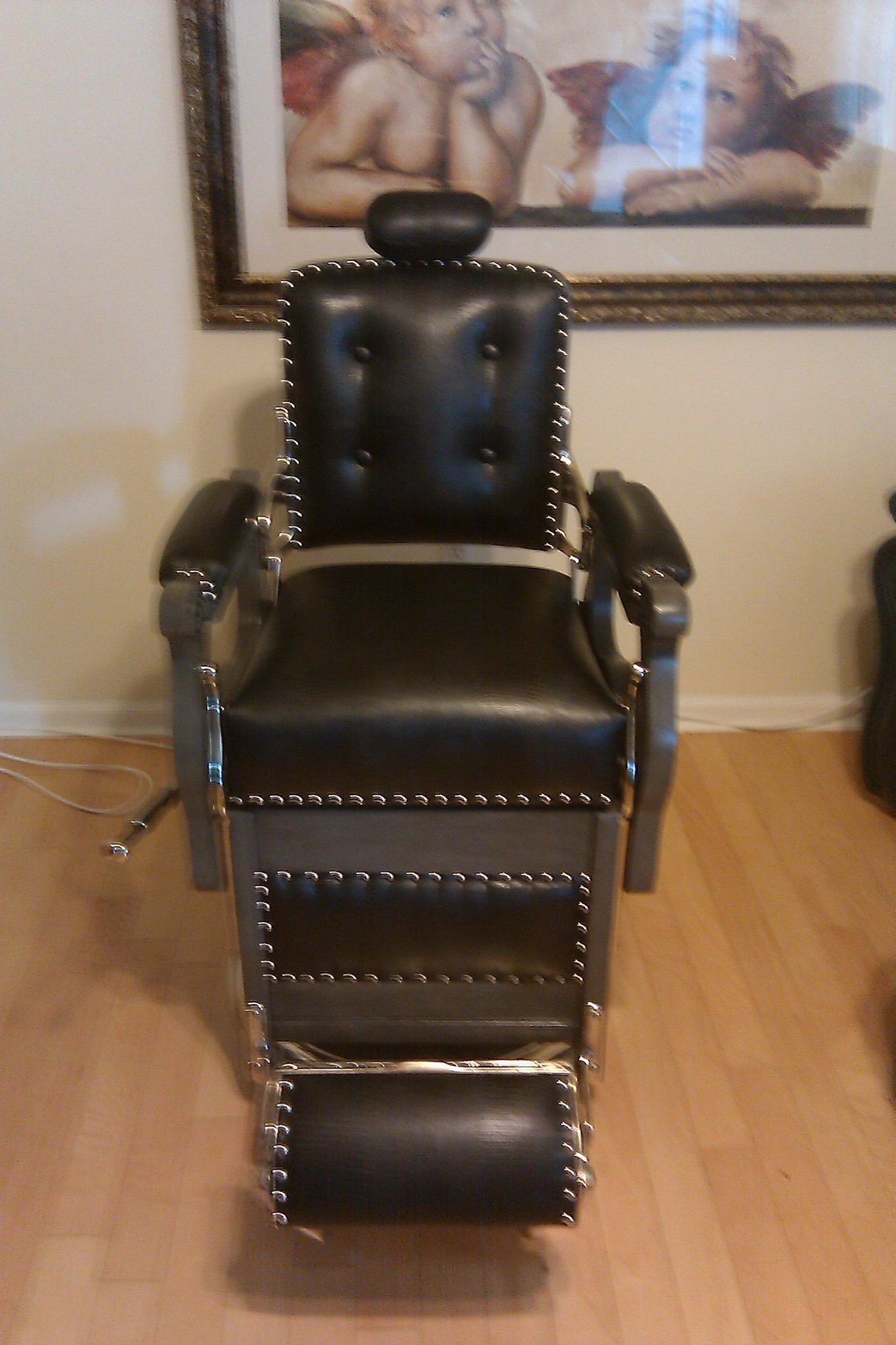 a black barber chair is sitting in front of a picture of a baby