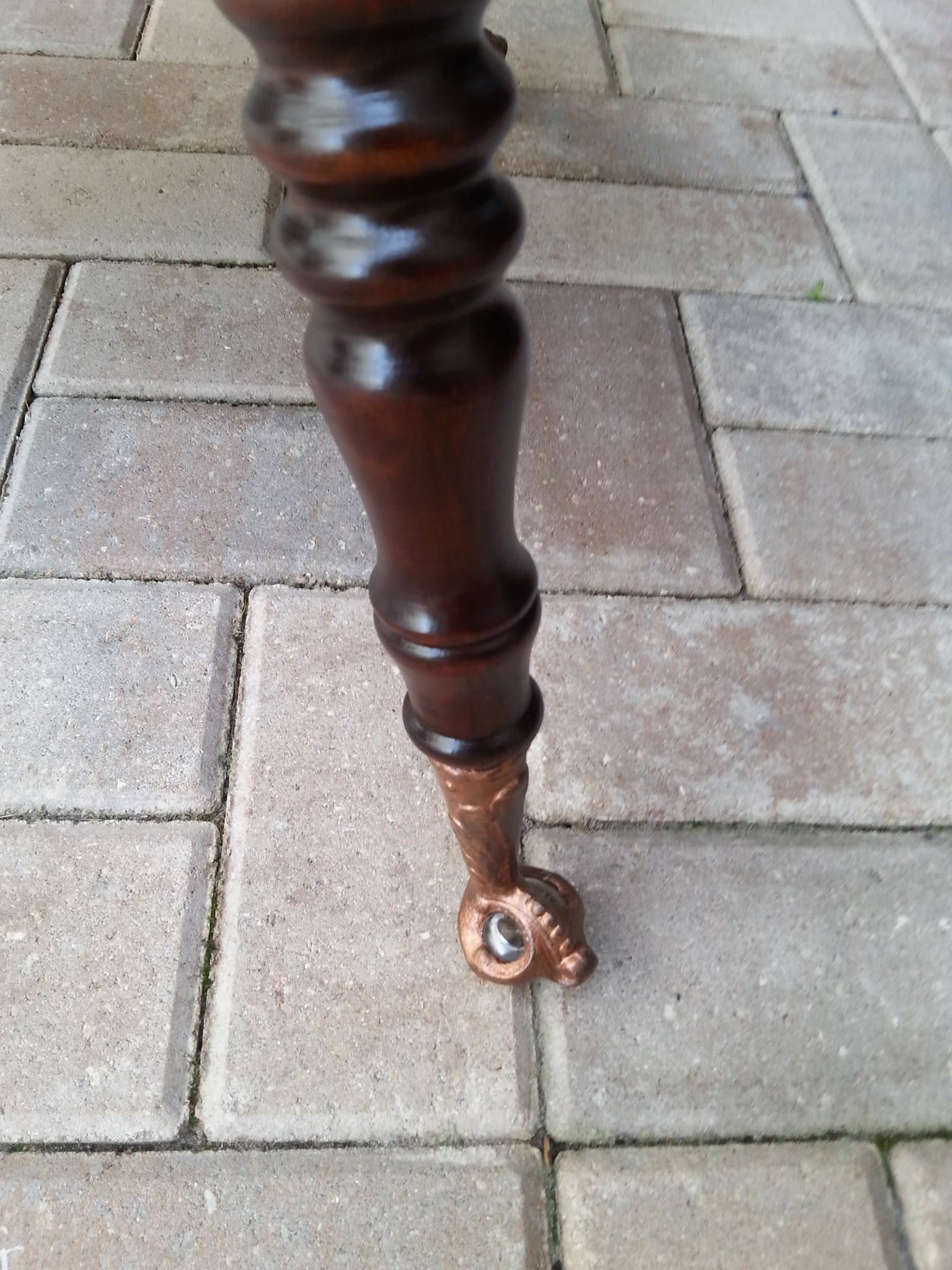 a close up of a wooden leg on a brick floor
