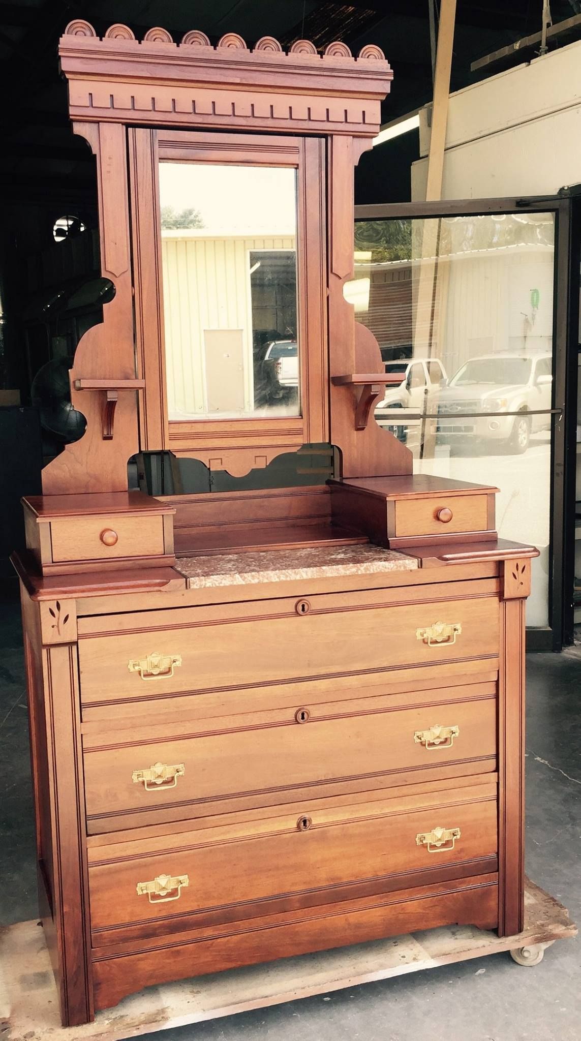 a wooden dresser with a mirror on top of it