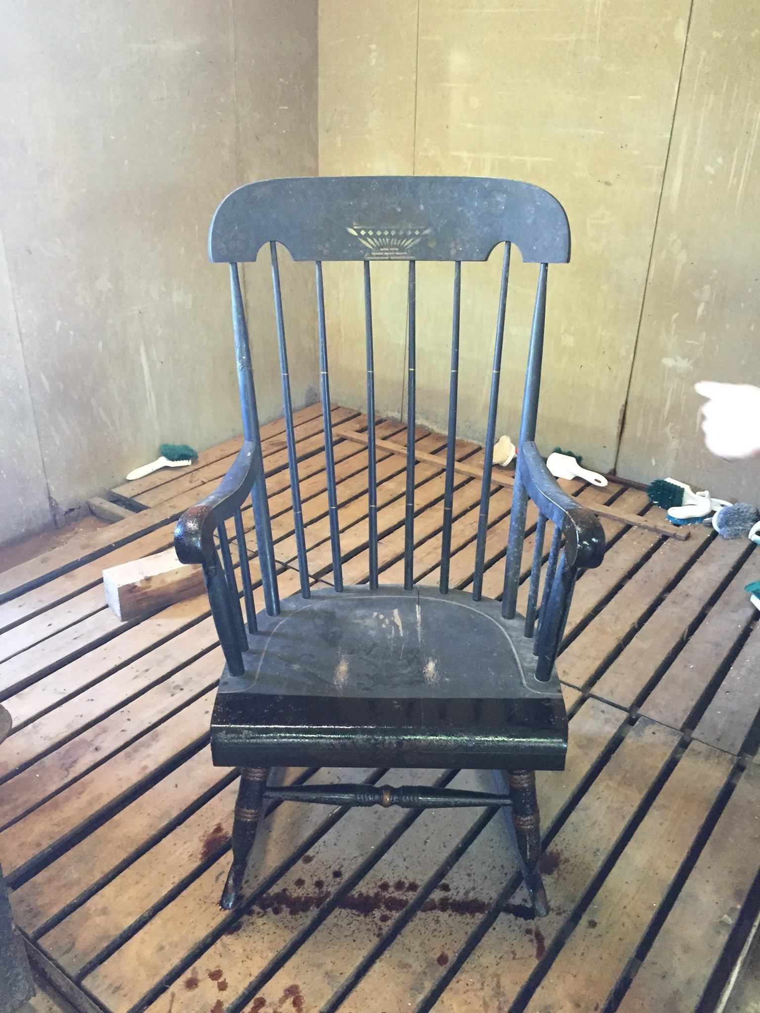 a wooden rocking chair is sitting on a wooden floor in a room