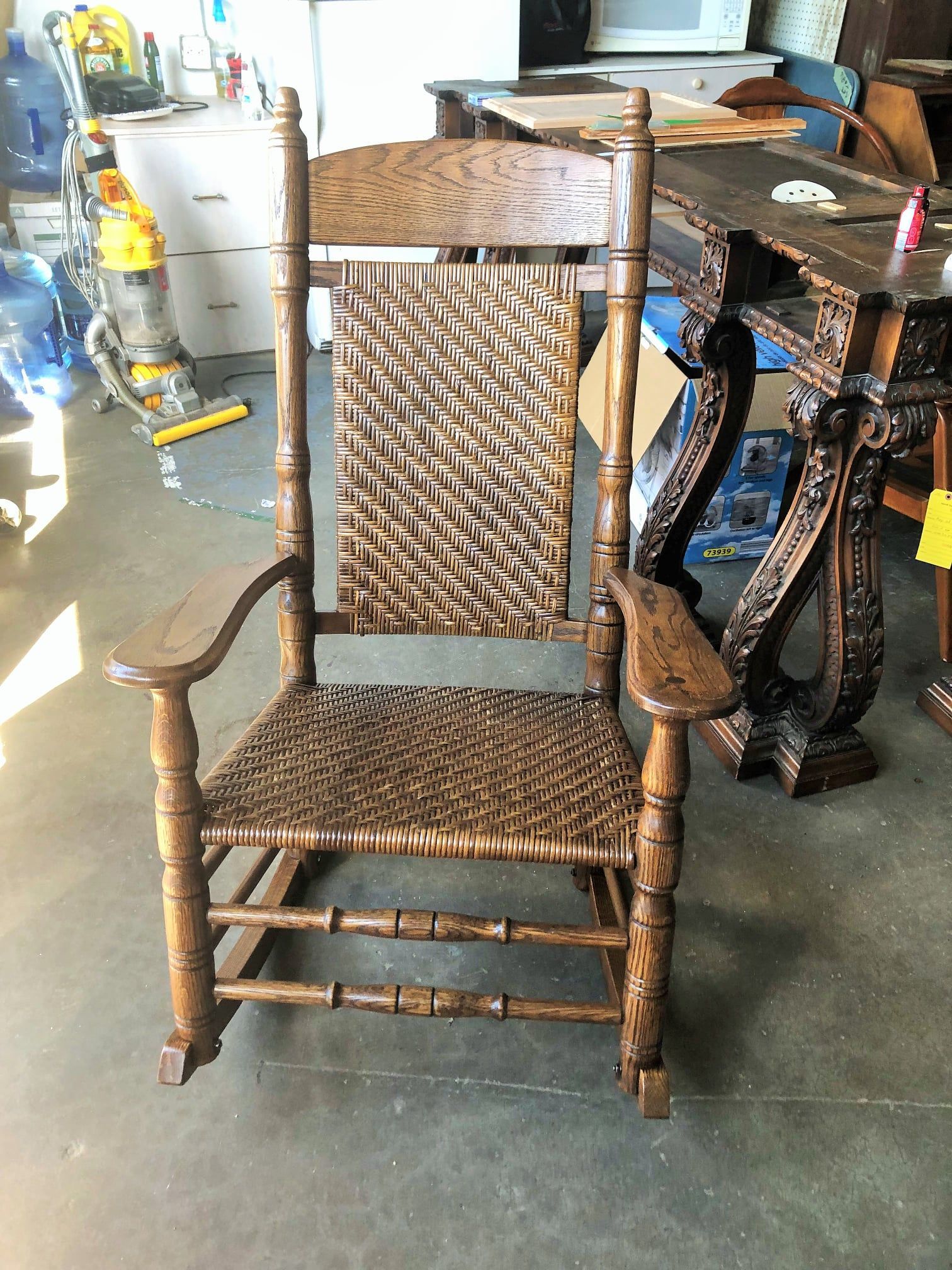 a wooden rocking chair is sitting in a room next to a table