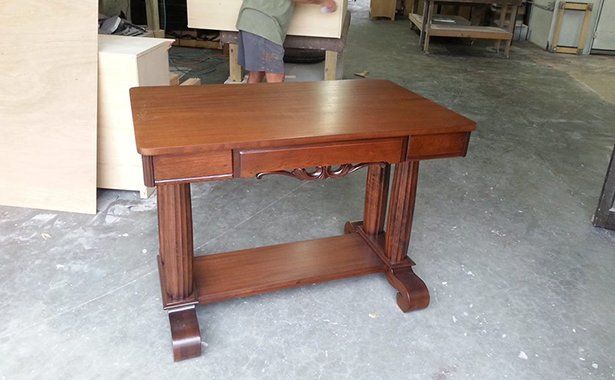 a small wooden table with a drawer underneath it