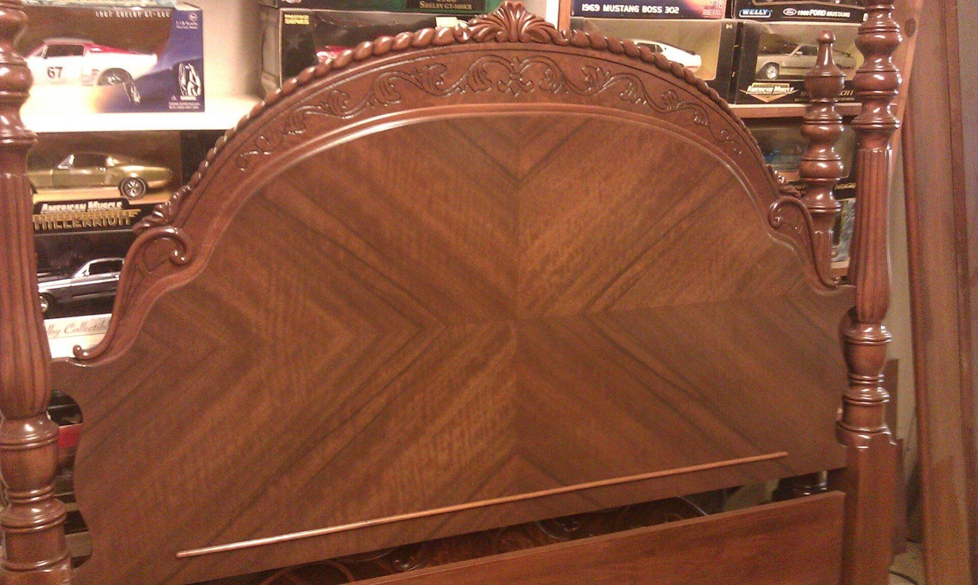a wooden headboard with a car on a shelf in the background