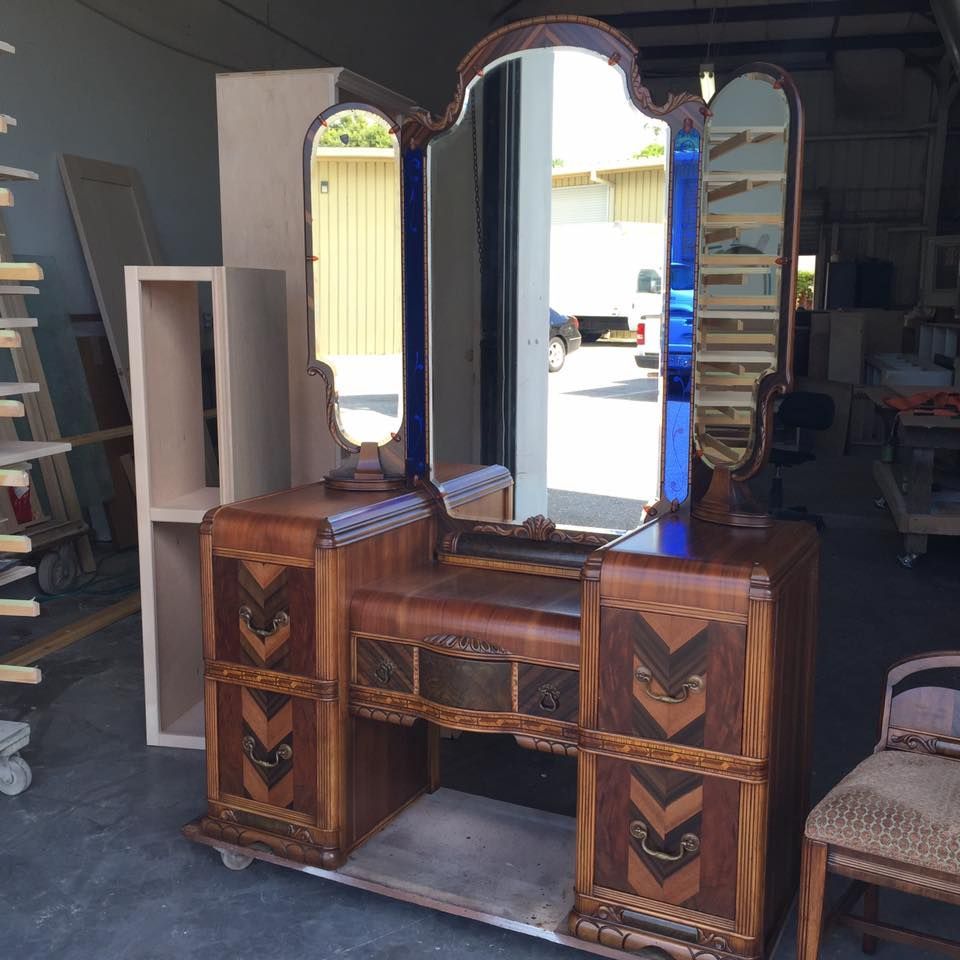 a wooden vanity with two mirrors and arrows on the drawers