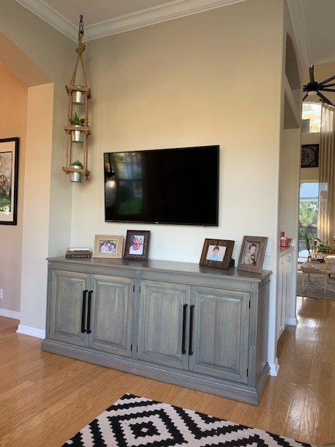 a living room with a tv on the wall and a rug