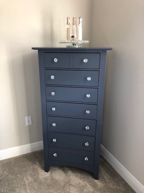 a blue chest of drawers is sitting in a corner of a room