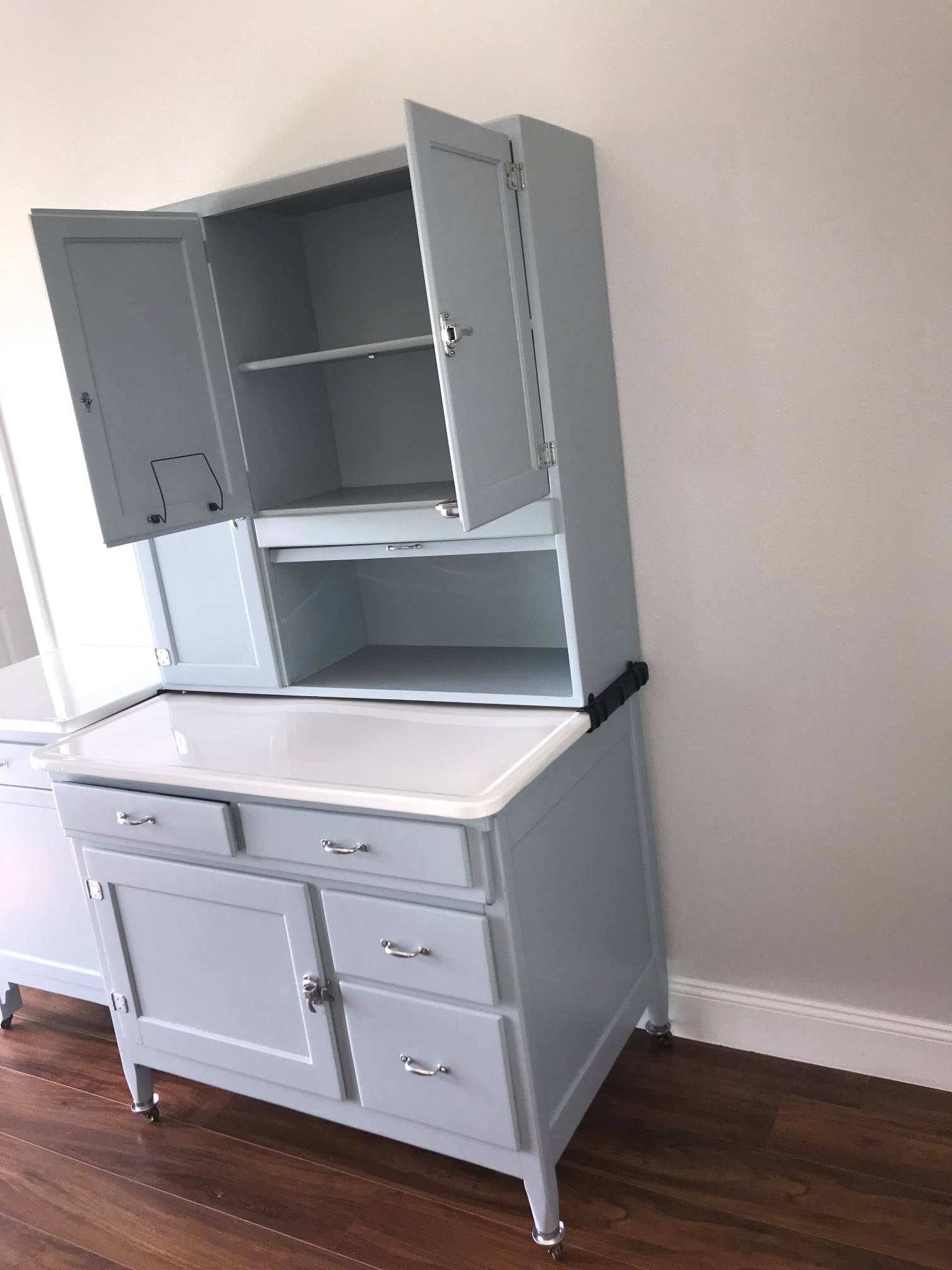 a gray cabinet with a white countertop sits on a wooden floor in a room 