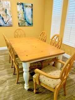 a dining room with a table and chairs and a painting on the wall